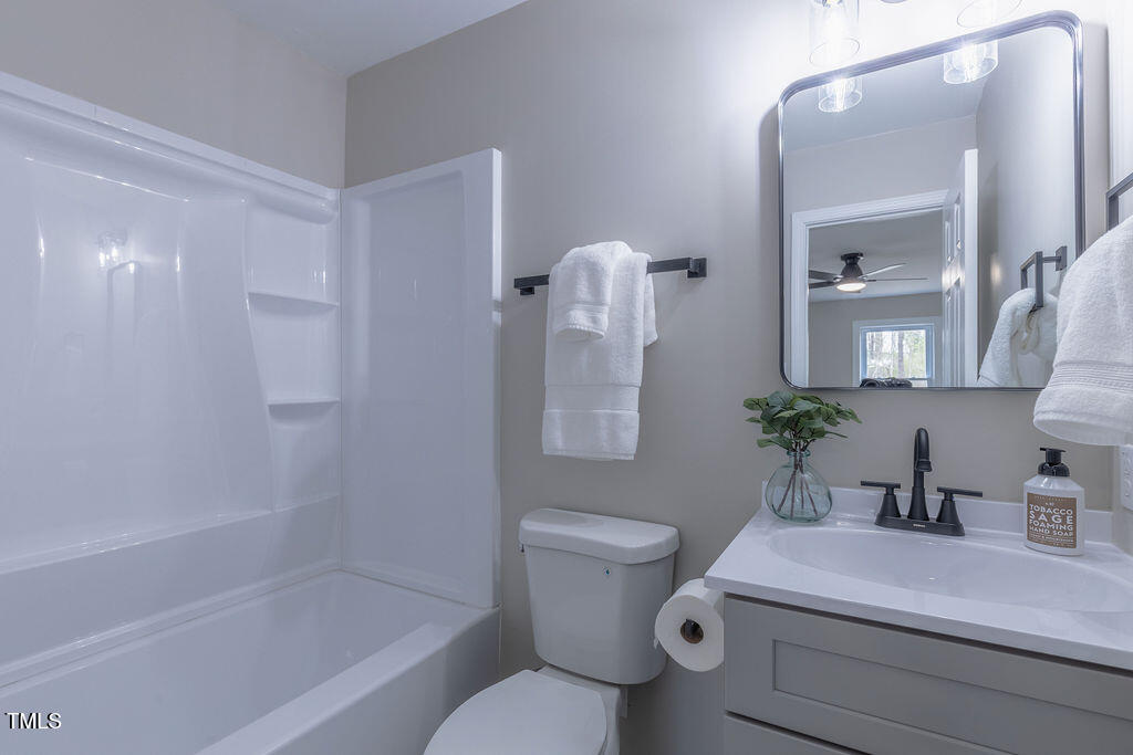 4814 Fayetteville Road Durham, NC 27713 - Photo 24 of 32 a bathroom with a sink a toilet a mirror and shower