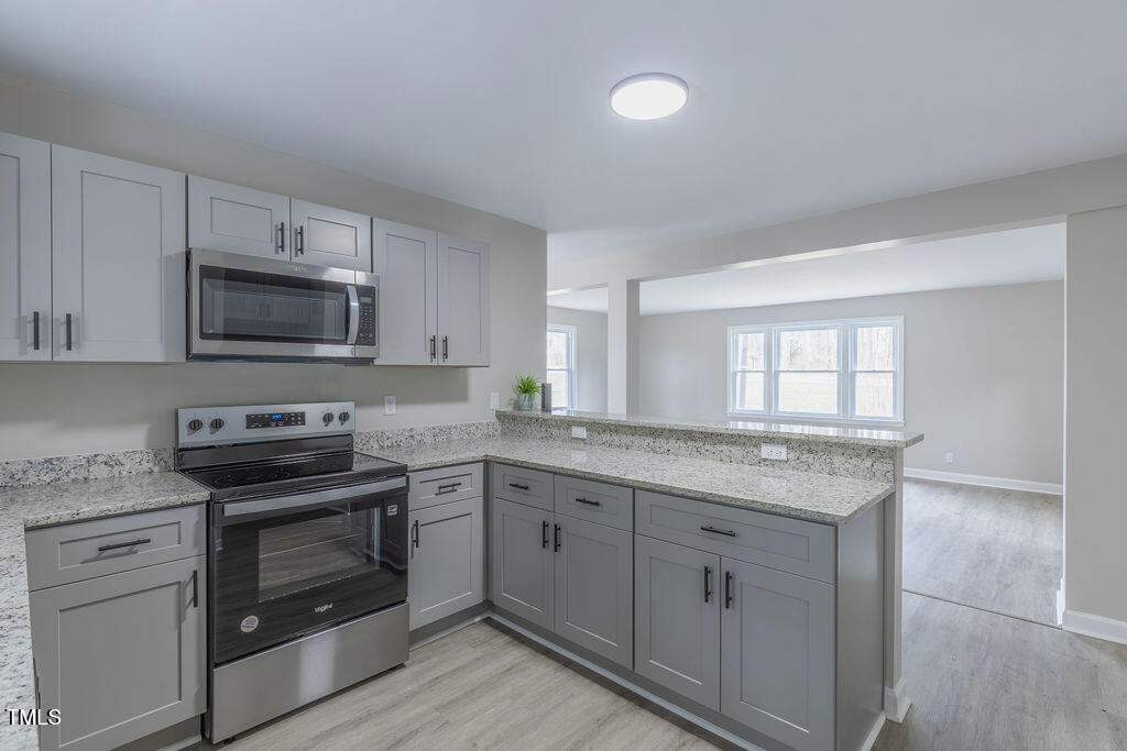 4814 Fayetteville Road Durham, NC 27713 - Photo 7 of 32 a kitchen with granite countertop white cabinets and a stove top oven