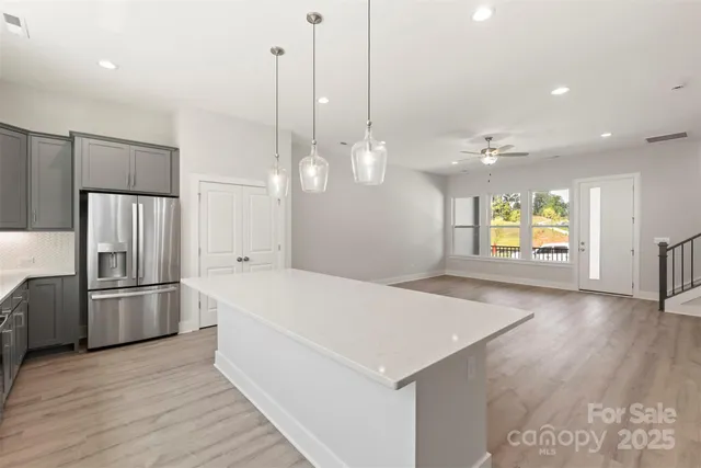 a very nice looking room with a large kitchen space wooden floor and a refrigerator