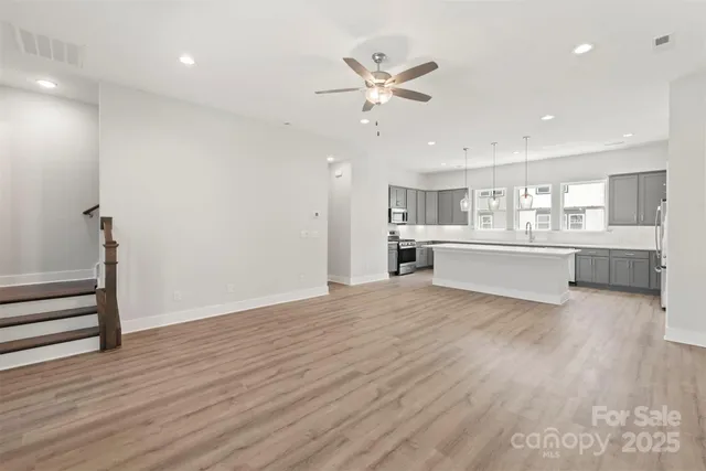 a view of a kitchen with wooden floor and a sink