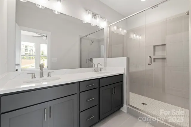a bathroom with a double vanity sink mirror double and shower
