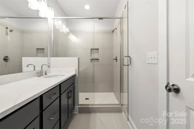 a bathroom with a shower sink and mirror