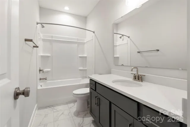 a bathroom with a granite countertop sink a toilet and shower