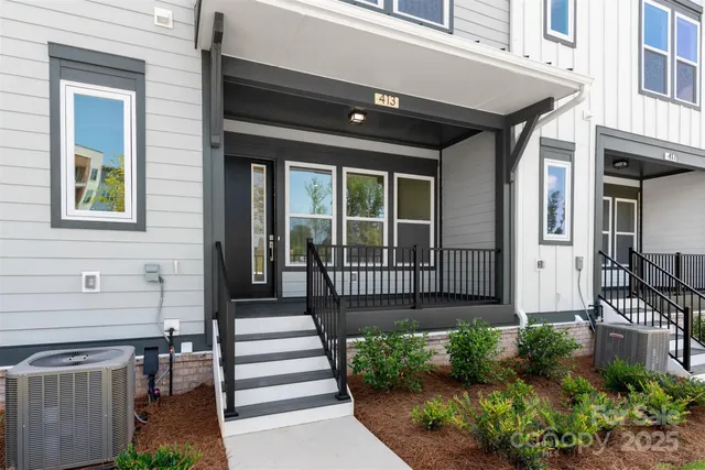 a view of a house with a small yard and wooden floor and outdoor seating