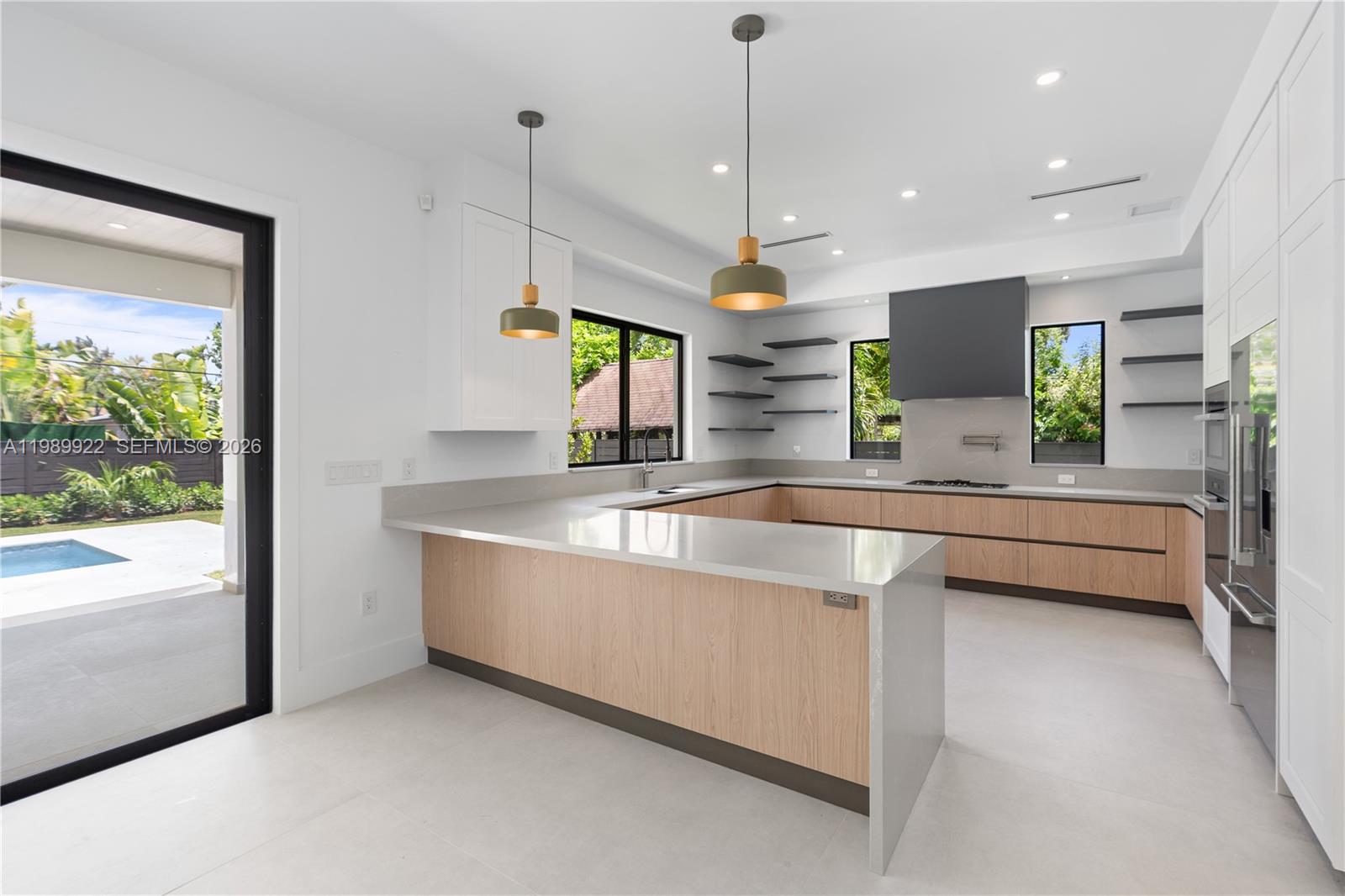 6221 Southwest 60th Street South Miami, FL 33143 - Photo 5 of 42 a large kitchen with kitchen island a large counter top a sink a stove and a window