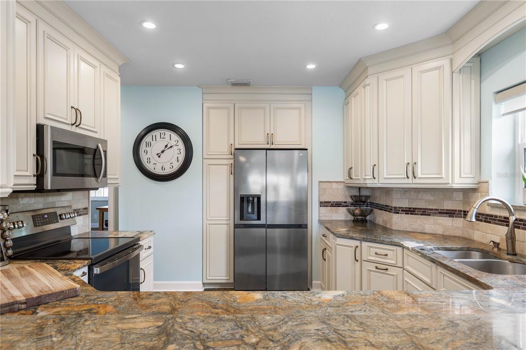 102 Rivers Edge Lane, Unit 102 Palm Coast, FL 32137 - Photo 22 of 67 a kitchen with stainless steel appliances granite countertop a refrigerator a stove and a sink