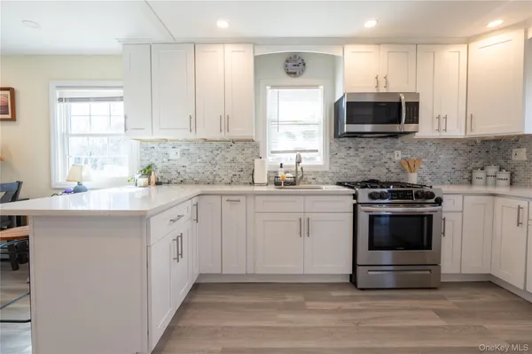 a kitchen with stainless steel appliances a stove microwave and sink