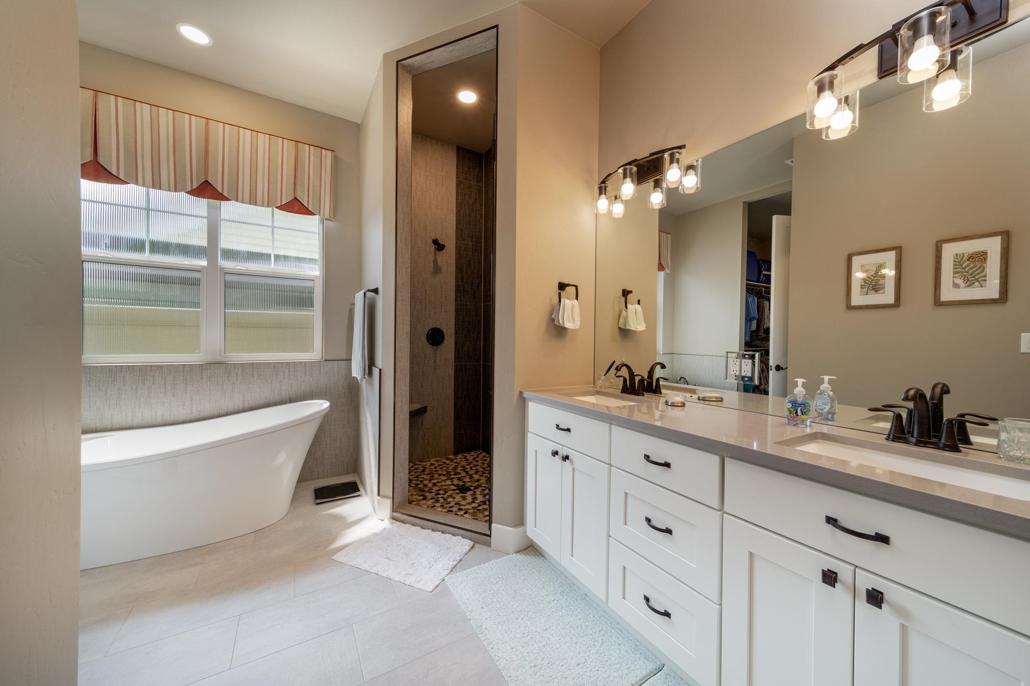 824 Red Apple Road Grand Junction, CO 81505 - Photo 15 of 25 a spacious bathroom with a double vanity sink a large mirror and a bathtub