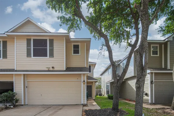 a front view of a house with a tree