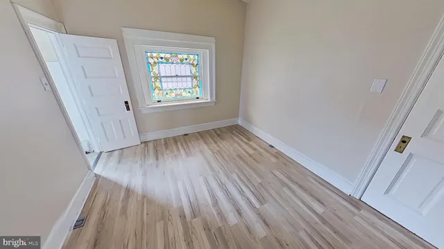 a view of a room with wooden floor and entryway