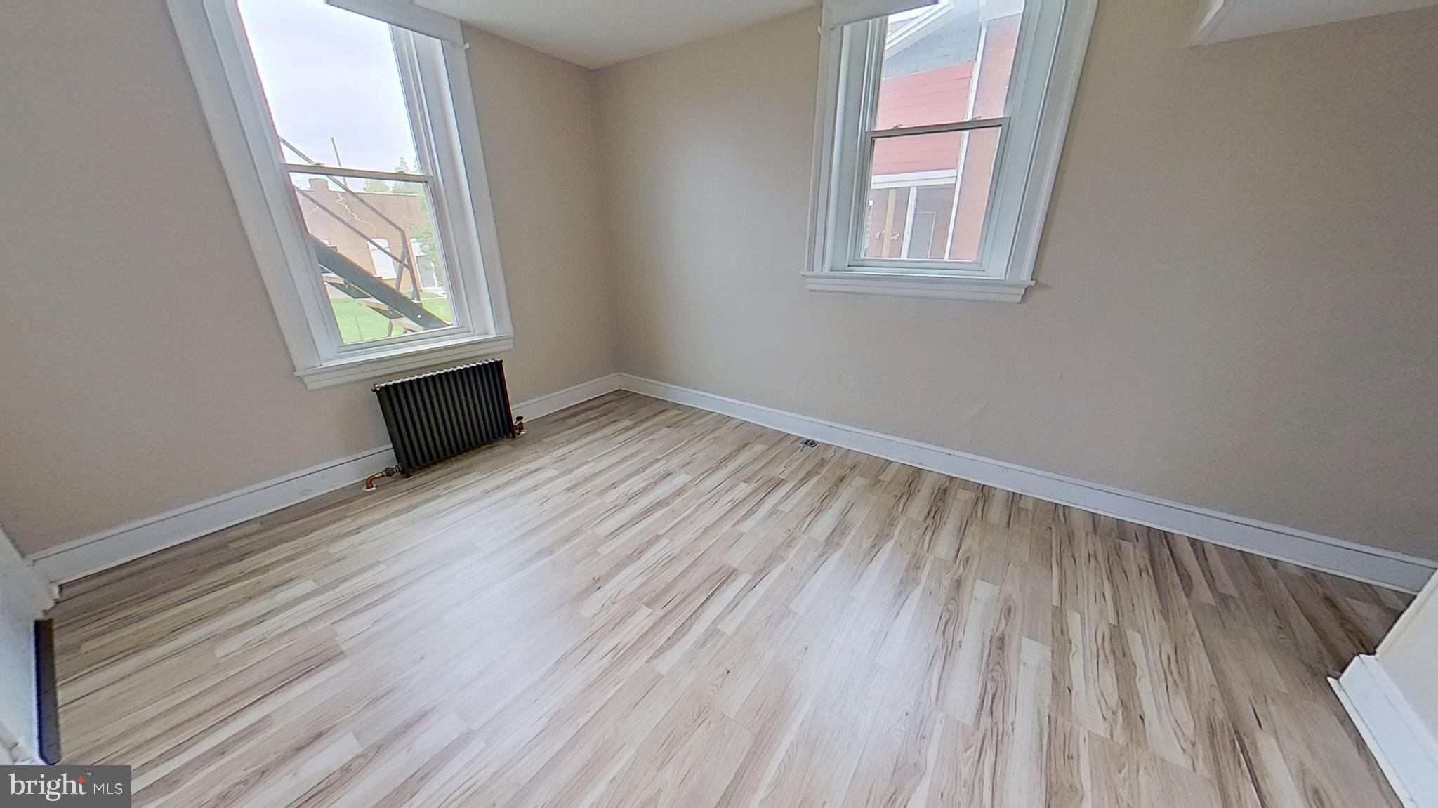 200 Carlisle Street, Unit A Hanover, PA 17331 - Photo 14 of 14 an empty room with wooden floor and windows