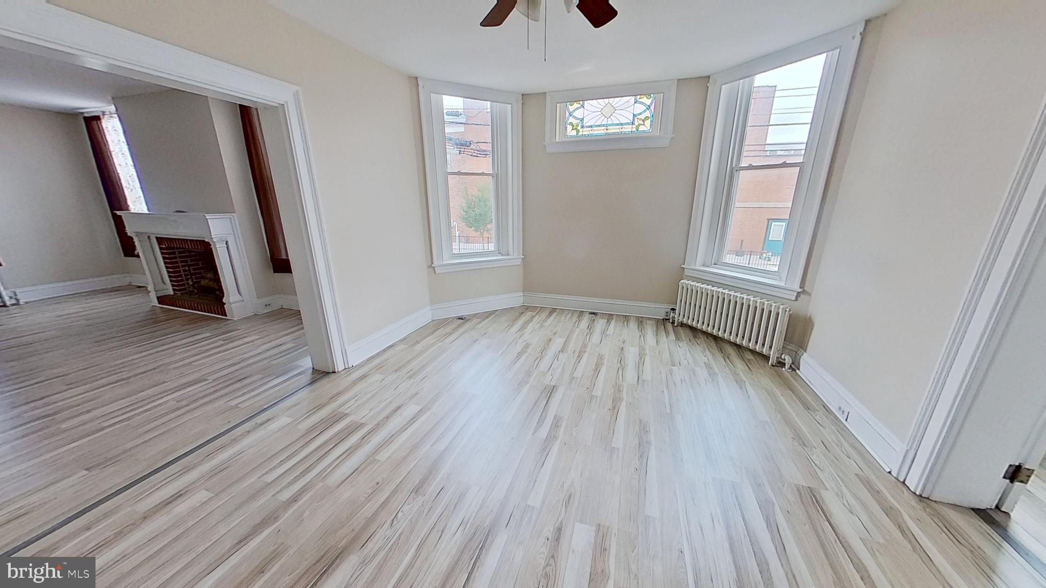 200 Carlisle Street, Unit A Hanover, PA 17331 - Photo 5 of 14 an empty room with wooden floor and windows