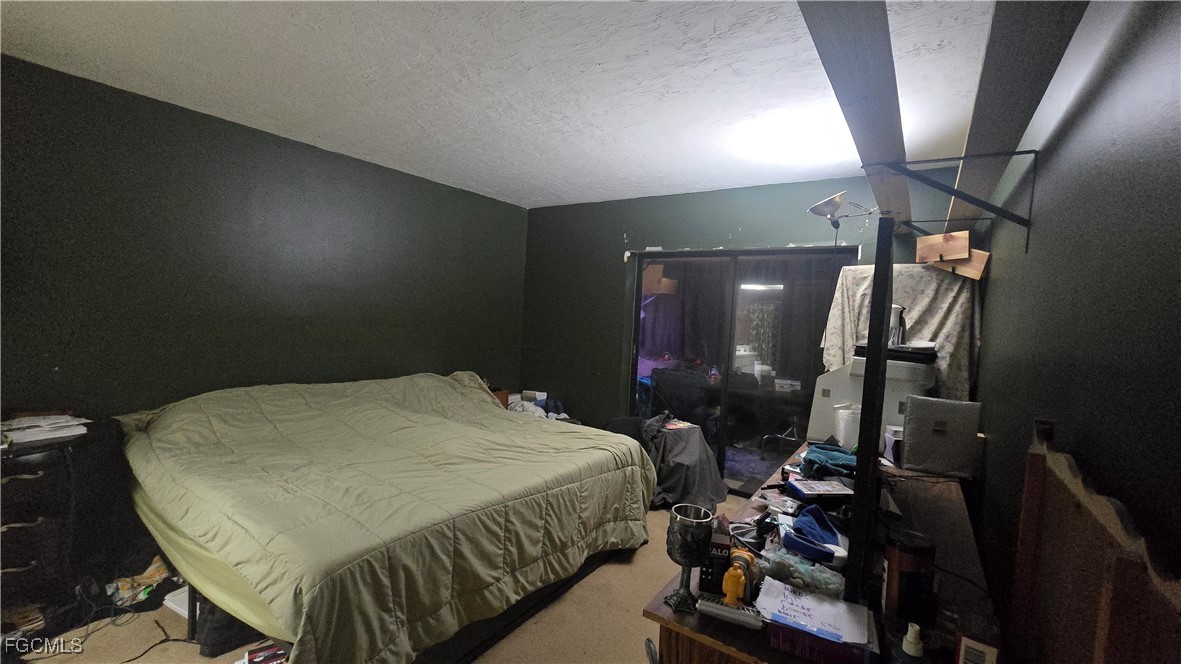 606 Gerald Avenue, Unit 112 Lehigh Acres, FL 33936 - Photo 12 of 17 a bedroom with a bed a mirror and furniture