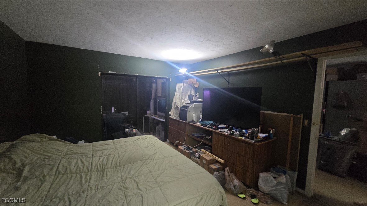 606 Gerald Avenue, Unit 112 Lehigh Acres, FL 33936 - Photo 13 of 17 a bedroom with a bed and a mirror