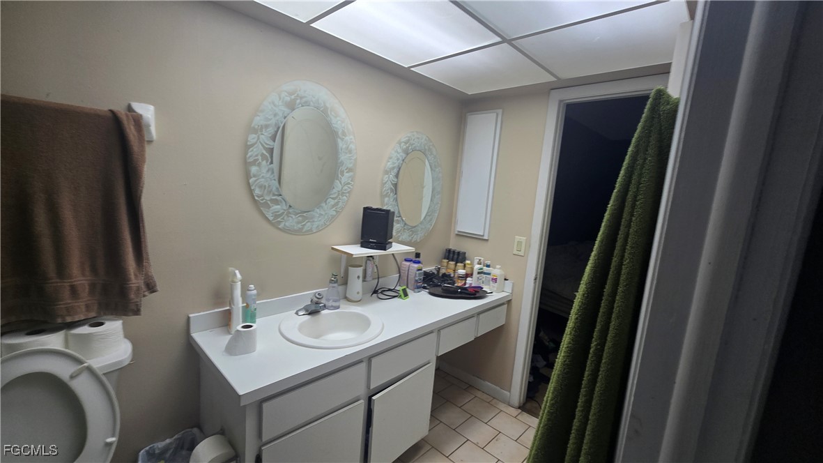 606 Gerald Avenue, Unit 112 Lehigh Acres, FL 33936 - Photo 16 of 17 a bathroom with a sink vanity and a mirror