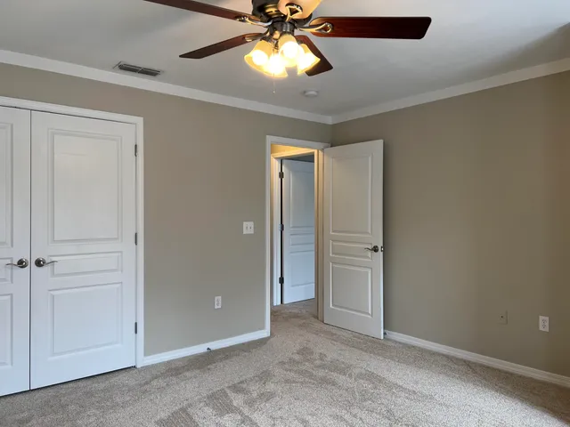 a view of backyard with large trees and wooden fence