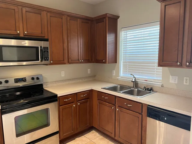 a kitchen with granite countertop cabinets stainless steel appliances a sink and dishwasher