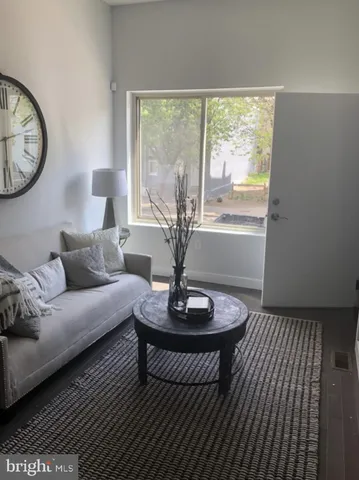 a living room with furniture a clock and a large window