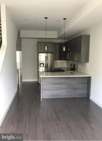 a view of a kitchen with kitchen island a sink stainless steel appliances and cabinets