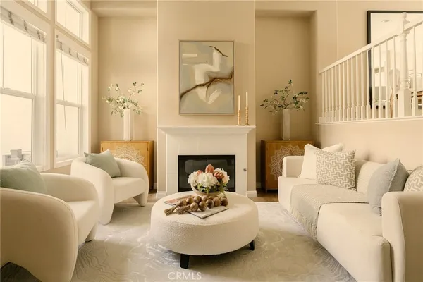a living room with furniture a fireplace and a large window