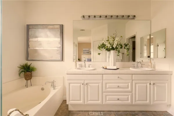 a bathroom with a tub sink and mirror