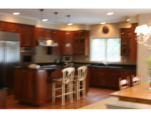 33 Wareland Road Wellesley, MA 02481 - Photo 3 of 7 a kitchen with stainless steel appliances wooden cabinets a sink and a refrigerator