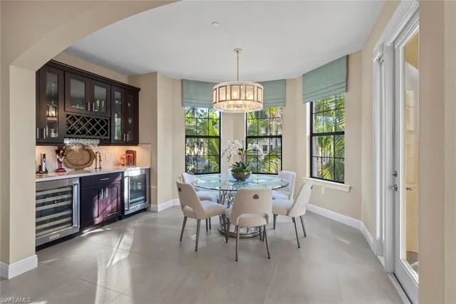 a kitchen with stainless steel appliances granite countertop a refrigerator a sink a stove and a dining table with wooden floor