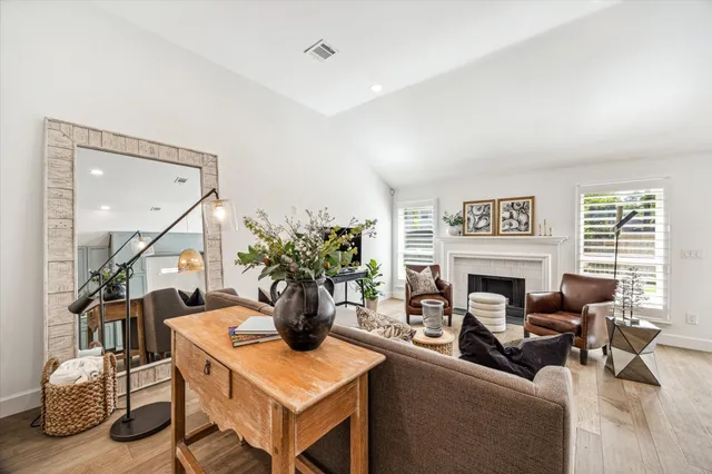 a living room with furniture a fireplace and a flat screen tv