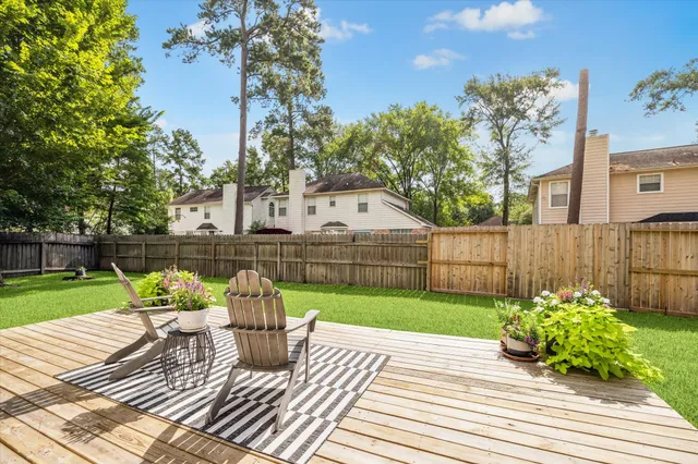 a front view of a house with a garden and trees