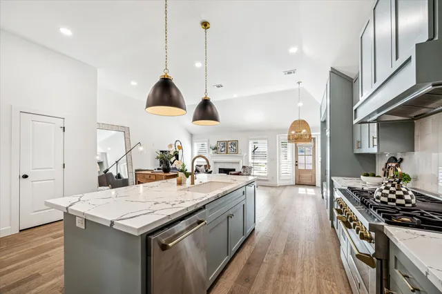 a kitchen with granite countertop a sink a counter space appliances and cabinets