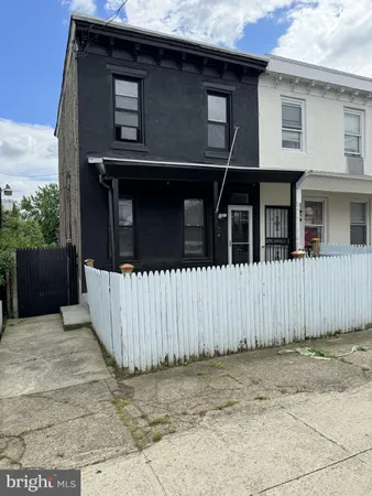 a side view of a house with a wooden fence