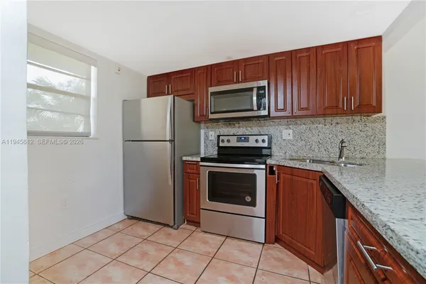 a kitchen with stainless steel appliances granite countertop a refrigerator stove and sink