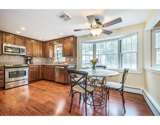 67 Wildwood Road Stow, MA 01775 - Photo 2 of 30 a open kitchen with stainless steel appliances granite countertop a stove top oven a refrigerator a dining table and chairs with wooden floor