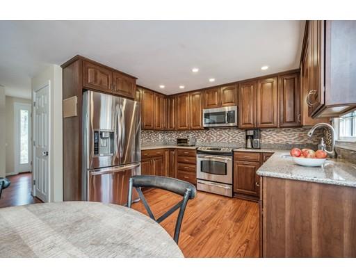 67 Wildwood Road Stow, MA 01775 - Photo 4 of 30 a kitchen with granite countertop wooden cabinets a refrigerator and a stove top oven