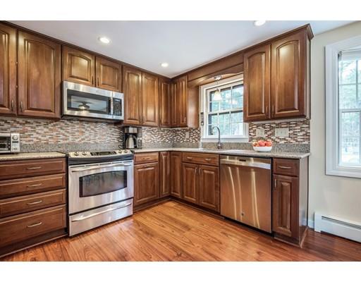 67 Wildwood Road Stow, MA 01775 - Photo 5 of 30 a kitchen with stainless steel appliances granite countertop wooden cabinets a stove a sink and dishwasher with wooden floor