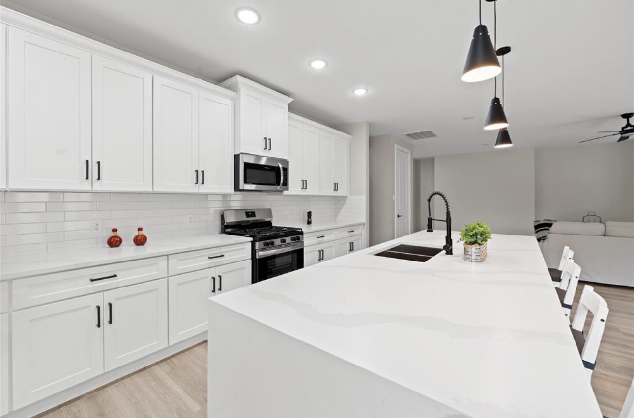 a kitchen with granite countertop white cabinets and appliances