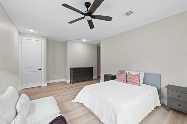 a bedroom with a large bed and a chandelier