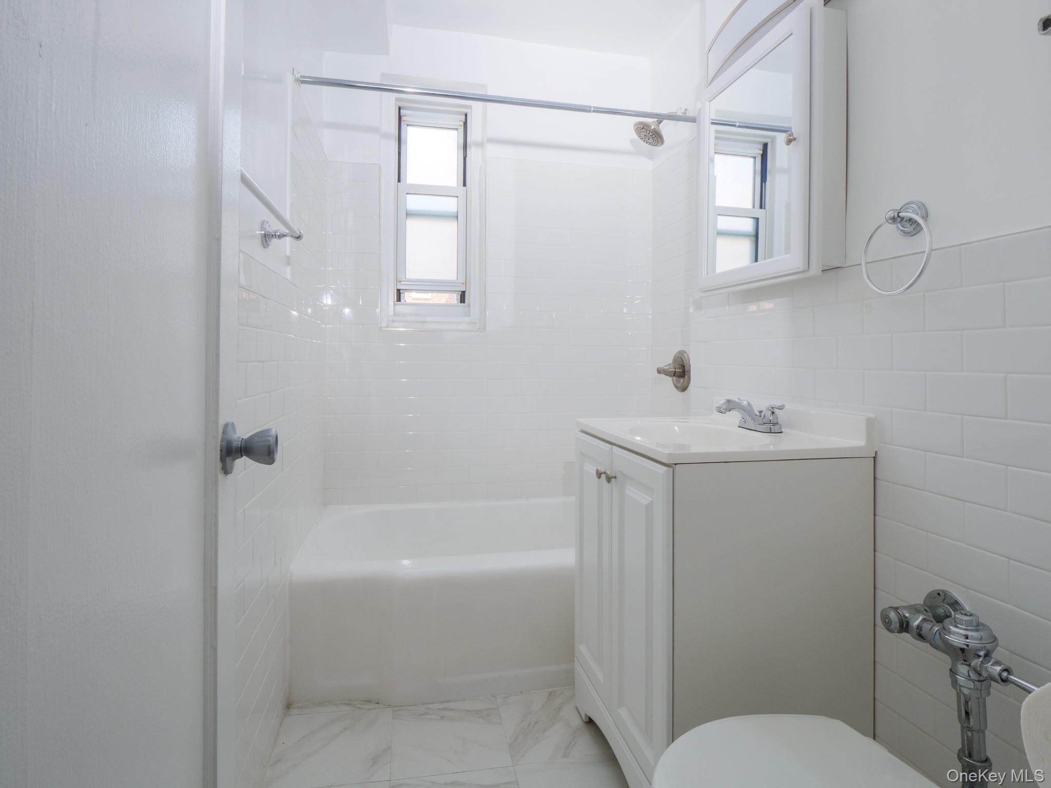 34-15 74th Street, Unit 4H Queens, NY 11372 - Photo 11 of 19 a bathroom with a sink a toilet and shower