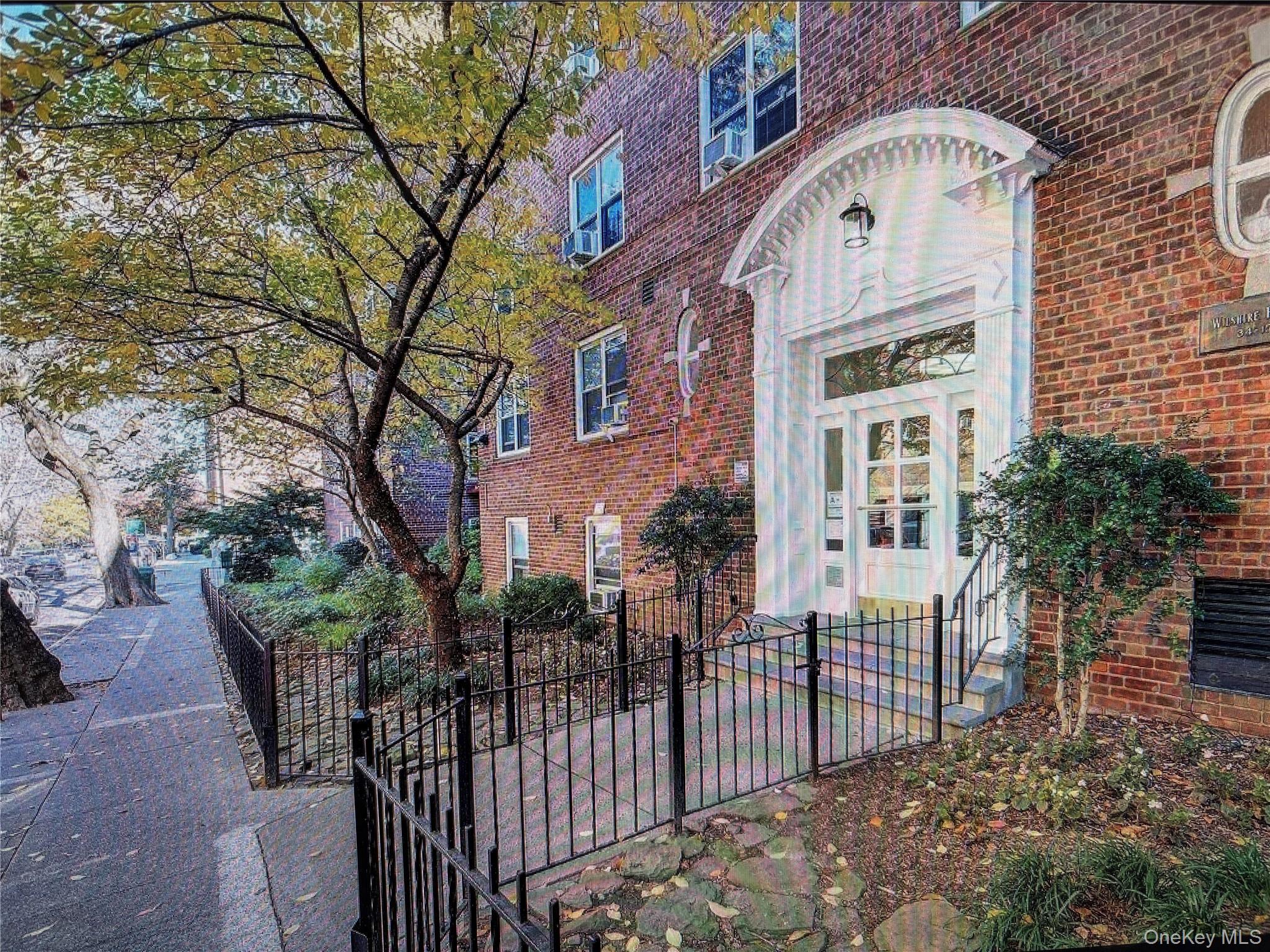 34-15 74th Street, Unit 4H Queens, NY 11372 - Photo 2 of 19 a view of a brick house with large windows and a table and chairs