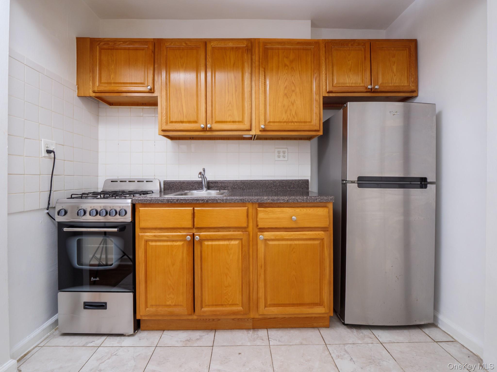 34-15 74th Street, Unit 4H Queens, NY 11372 - Photo 3 of 19 a kitchen with stainless steel appliances granite countertop a refrigerator and a stove