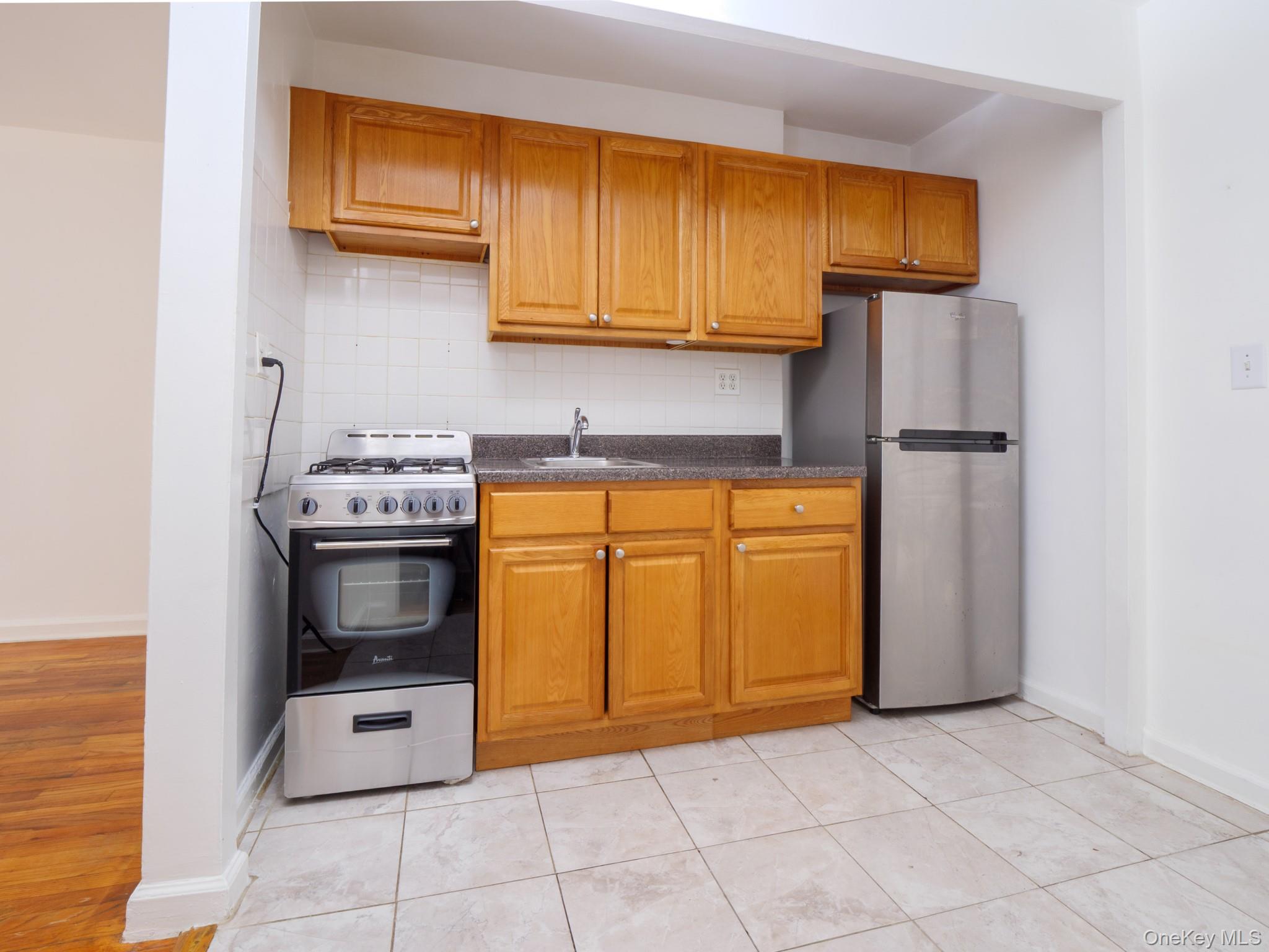 34-15 74th Street, Unit 4H Queens, NY 11372 - Photo 4 of 19 a kitchen with a sink a stove and cabinets