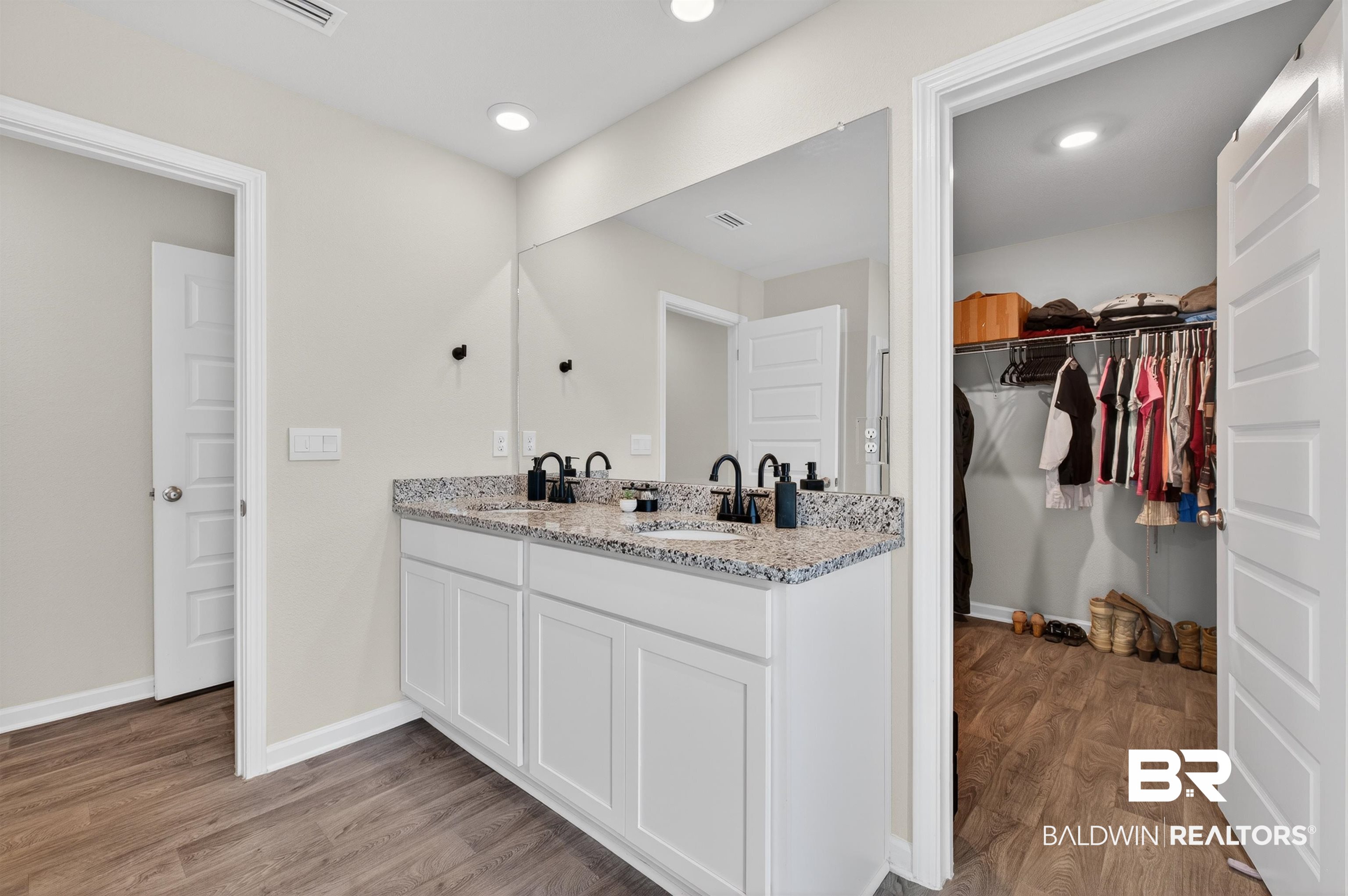 3213 Camino Real Loop Lillian, AL 36549 - Photo 42 of 61 Dual vanity with granite countertop and black fixtures, expansive mirror, recessed lighting, wood-finish flooring, and an open closet with organizational shelving
