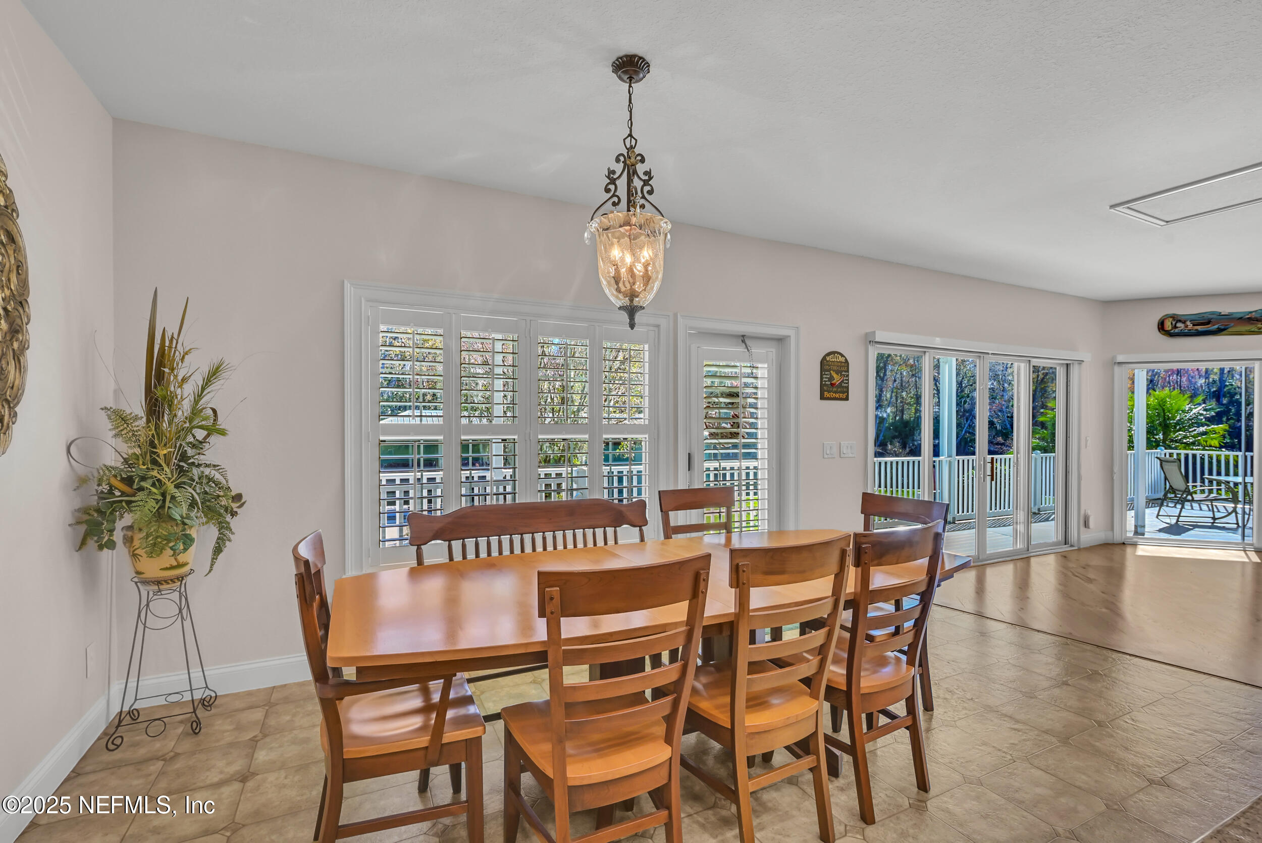 56633 Otter Road Astor, FL 32102 - Photo 13 of 69 a dining room with furniture a potted plant and a chandelier