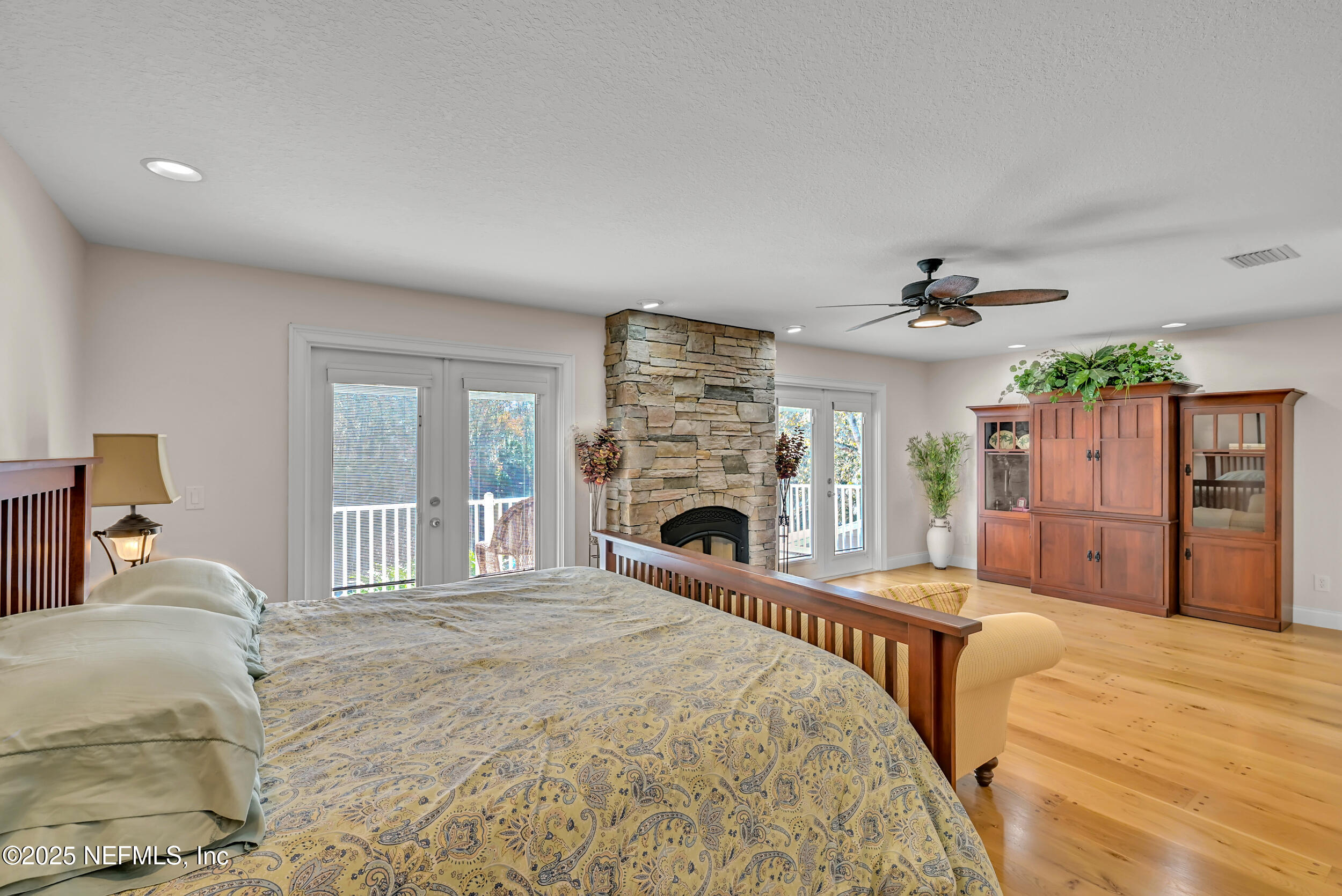 56633 Otter Road Astor, FL 32102 - Photo 21 of 69 a spacious bedroom with a large bed and a fireplace