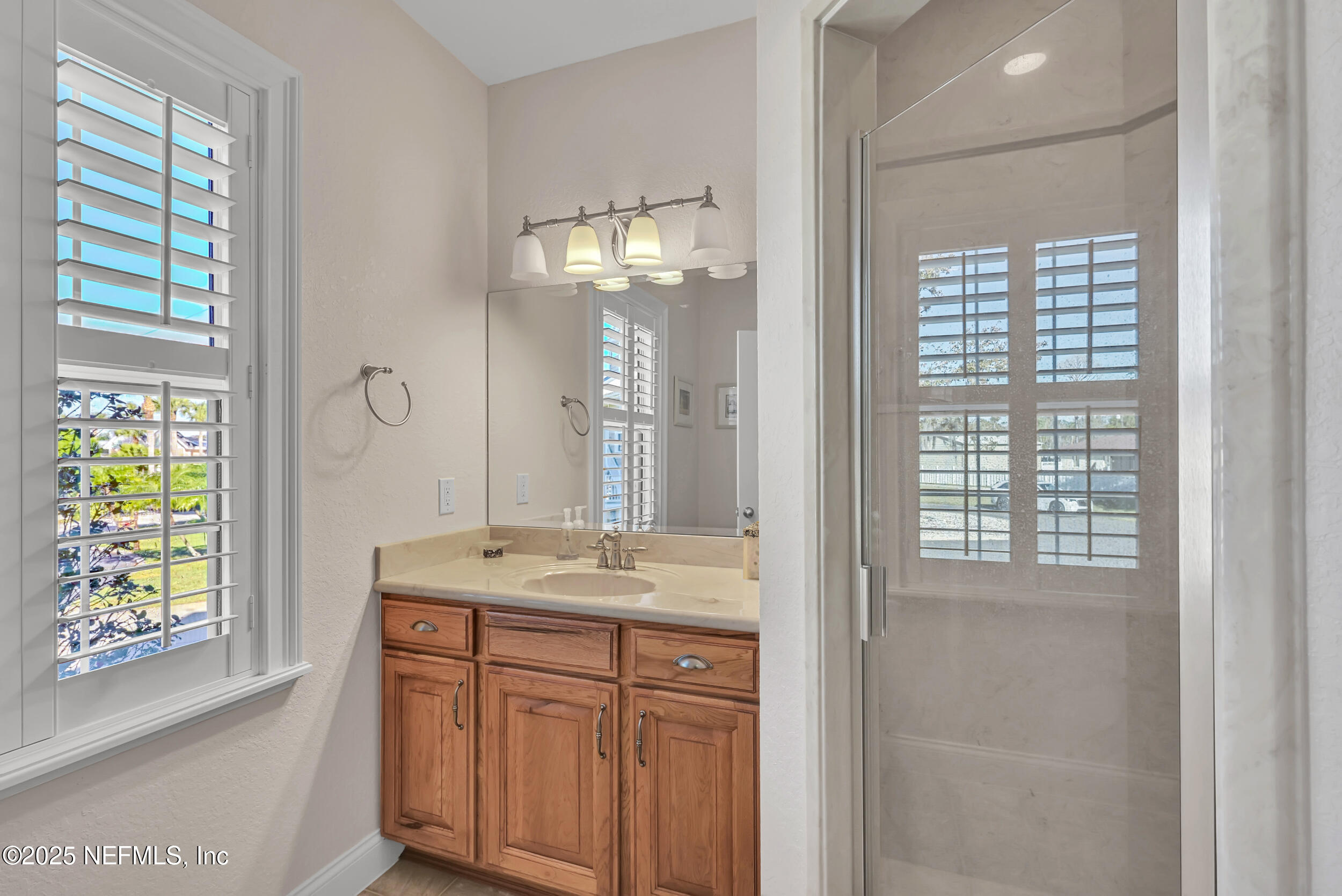 56633 Otter Road Astor, FL 32102 - Photo 33 of 69 a bathroom with a granite countertop sink a large mirror a vanity and next to a window