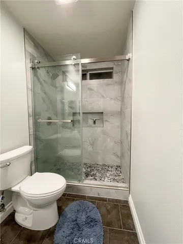 a bathroom with a toilet and a shower