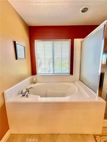 a spacious white bath tub sitting in a bathroom next to a window