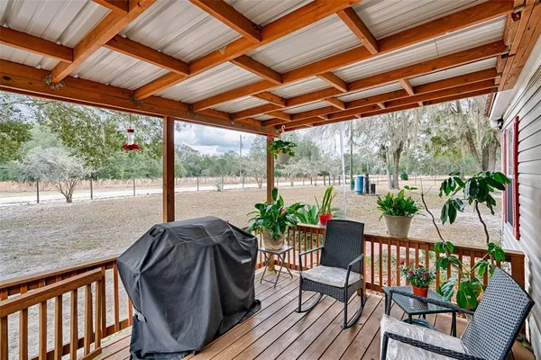 a view of porch with a table chairs