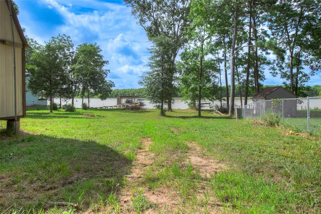 a view of grassy field with benches and trees all around