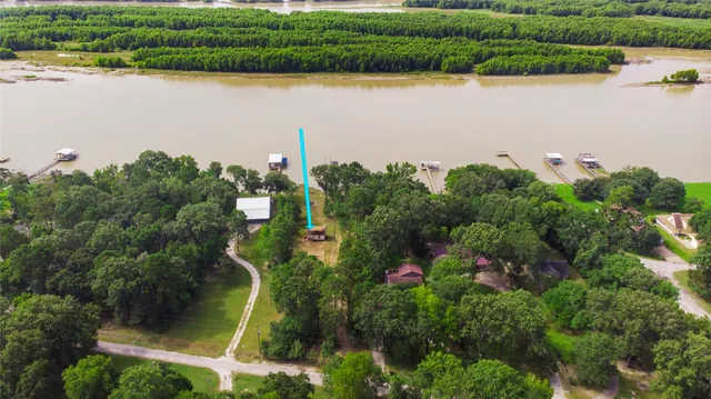 an aerial view of a house with a yard and lake view
